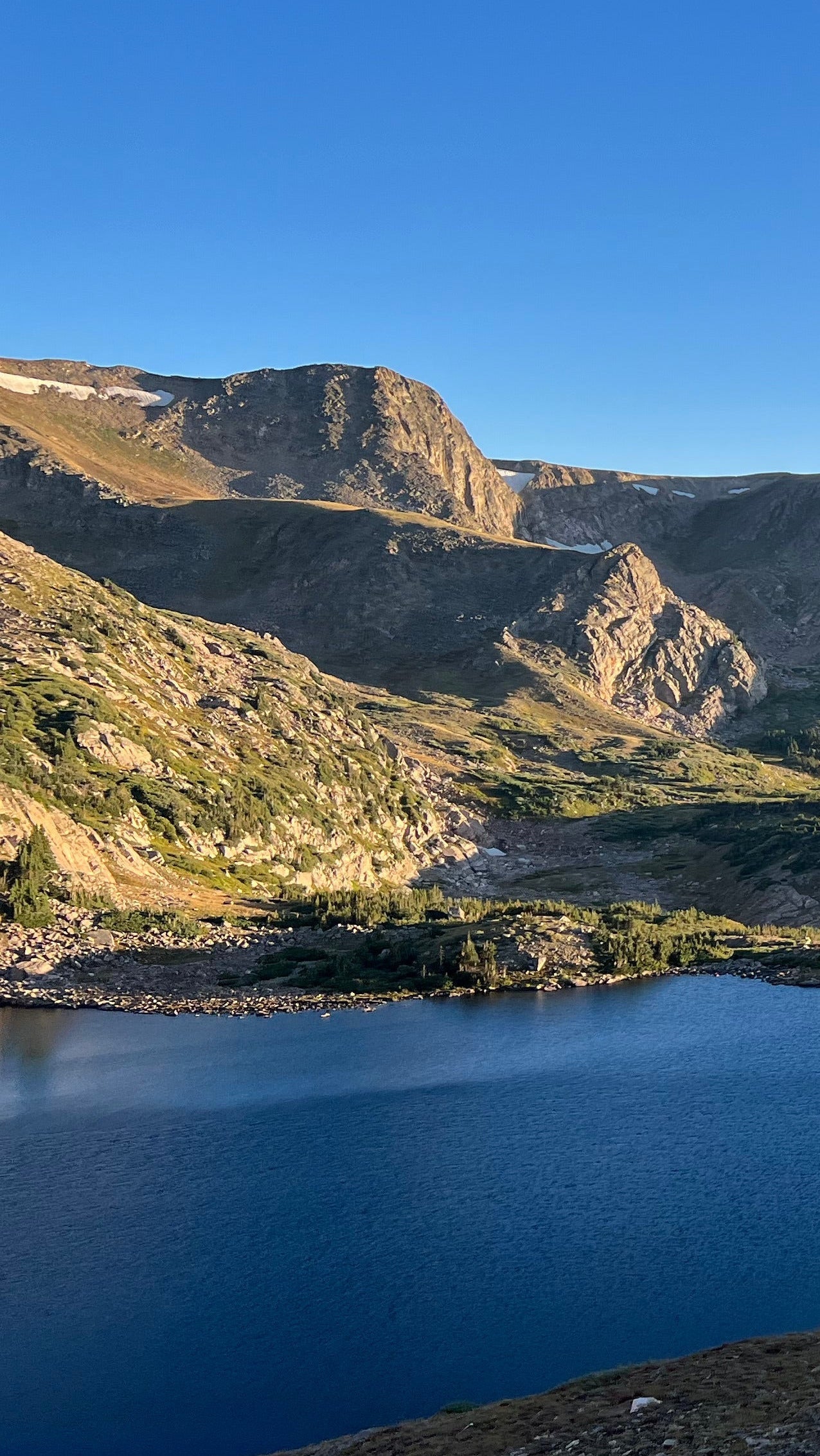 Photo of an alpine lake in Colorado surrounded by mountain peaks.