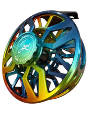 A close-up of a fly fishing reel with a vibrant iridescent rainbow finish, resting on a brown textured tile floor. The center cap features the brand name 'Abel' and 'Model Sky' with 'Made in USA' printed on it.