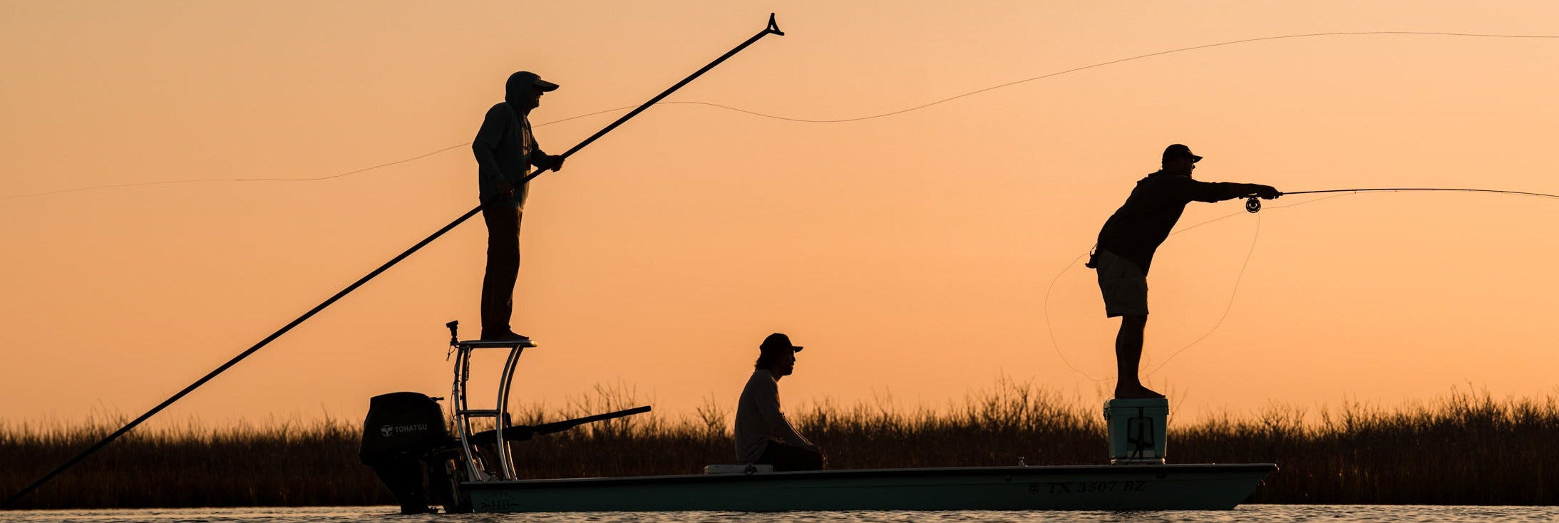 Three people fly fishing in a boat