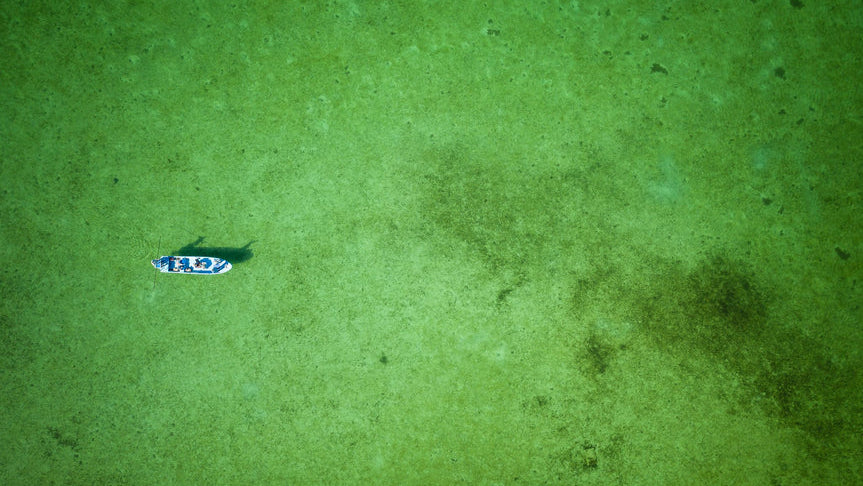 Small boat on a green textured surface