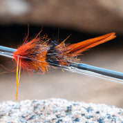 Close-up of a fly fishing fly on a hook against a natural background
